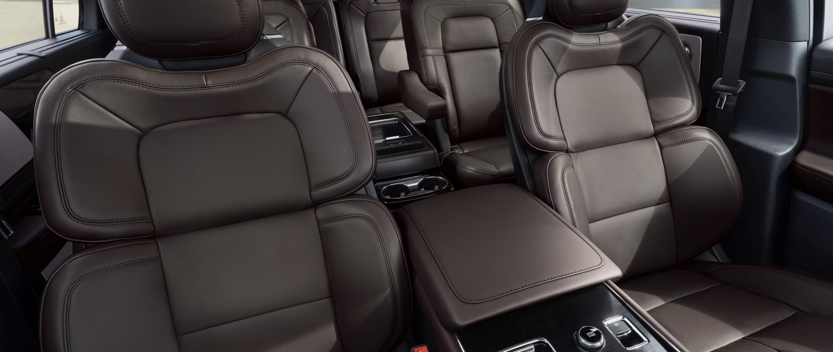 Interior view of a 2026 Lincoln Aviator showing dark brown leather front and second-row seats.