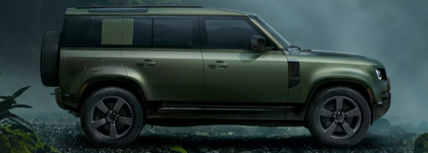 The green Defender 110 SUV is surrounded by fog.