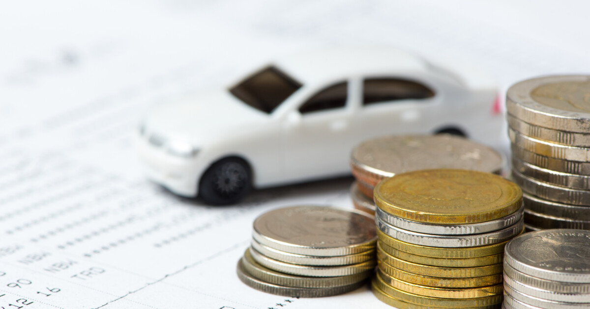 Tiny car with coins and finance paperwork