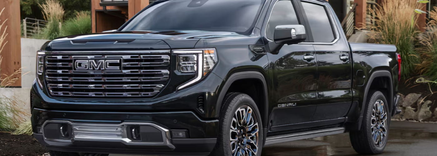This black Sierra 1500 is parked in front of a lodge.