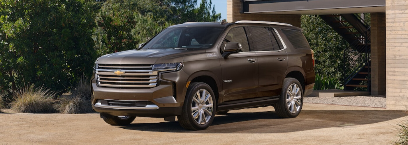 Brown Chevy Tahoe parked in front of trees