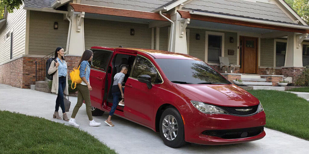 Red 2025 Chrysler Voyager parked in driveway
