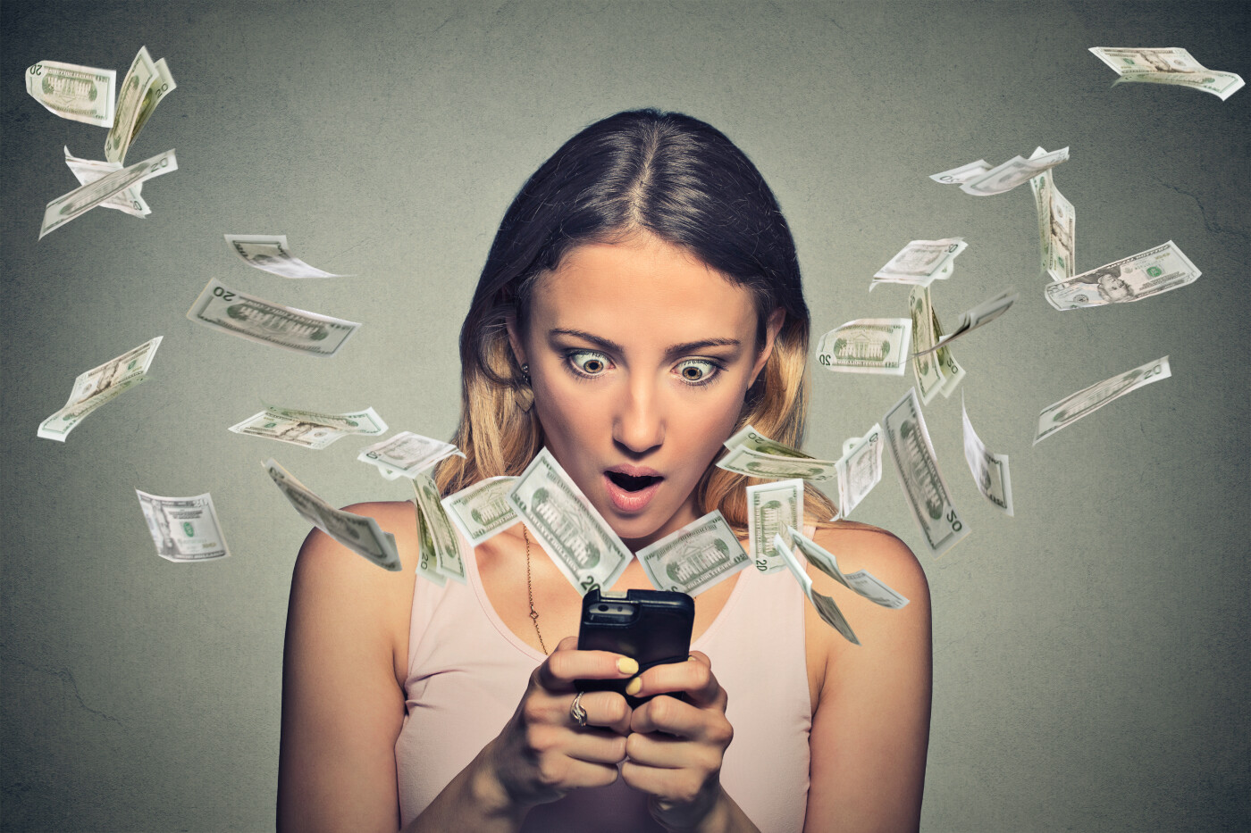 Surprised Woman Looking at Phone With Money Surprised Woman Looking at Phone With Money