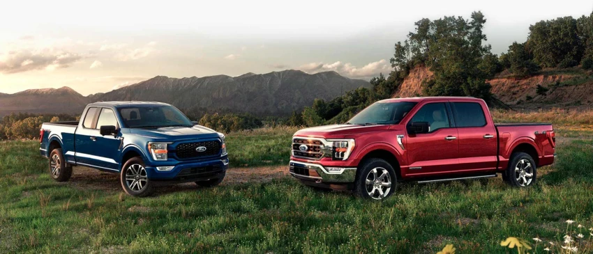2 2021 Ford F150's in a pasture at sunset