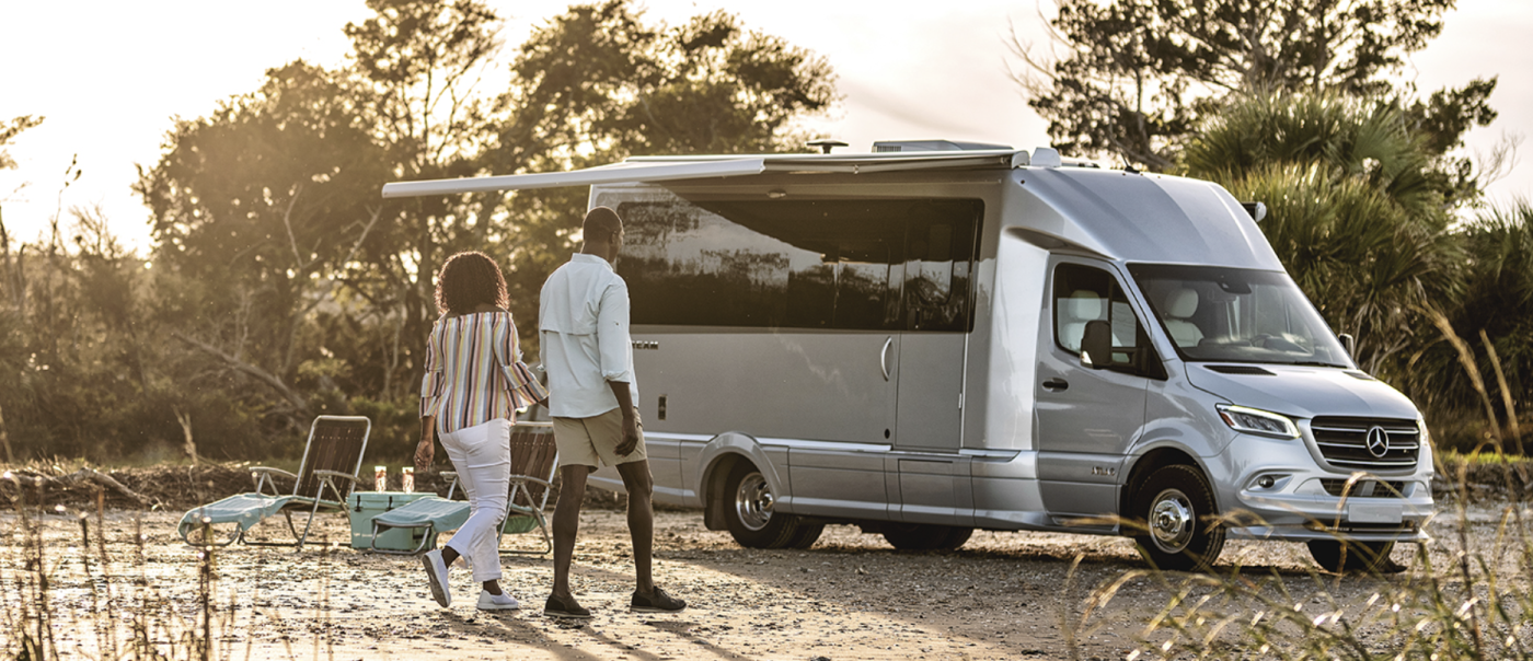 Couple camping outside with 2025 Airstream Atlas