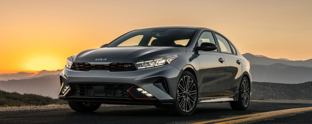 2022 Kia Forte driving down road at sunset