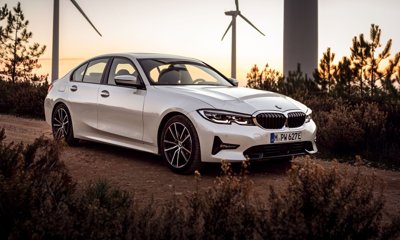2021 BMW 330i 2021 BWM 330i parked on a dirt road next to electrical wind turbines