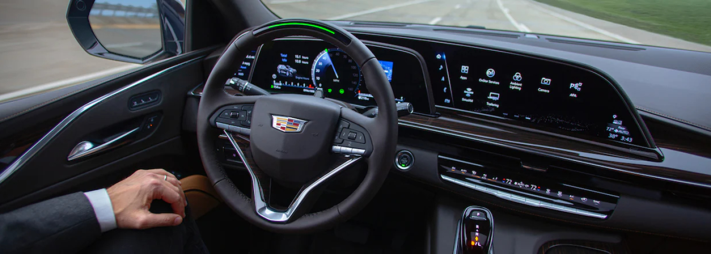 DRIVER ASSISTANCE, Cadillac Super Cruise button on steering wheel, man in cadillac using super cruise 