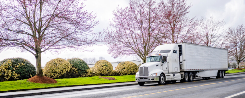 Semi-Truck Driving During Springtime White Semi-Truck Driving During Springtime