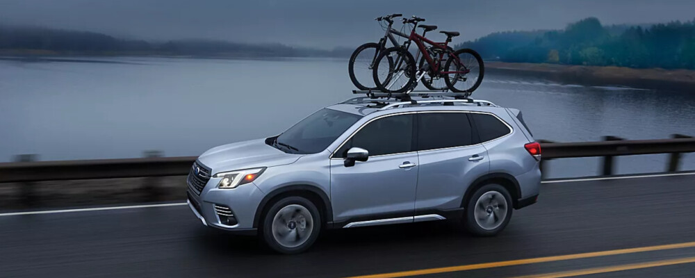 2023 Subaru Forester driving down road 2023 Subaru Forester driving down road with bikes on roof