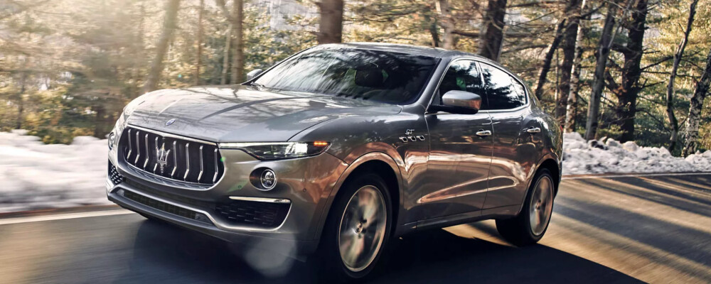 Beige Maserati Levante driving on road snow