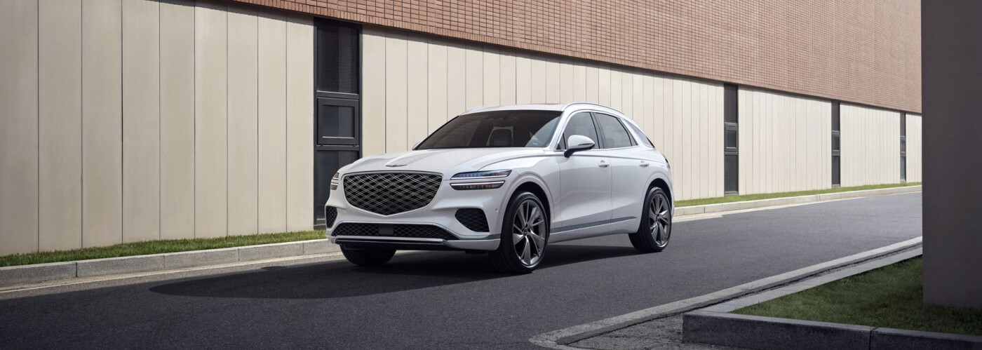 2026 White Genesis GV70 driving on street