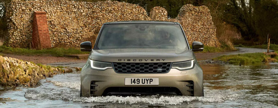 A Land Rover Defender driving through water