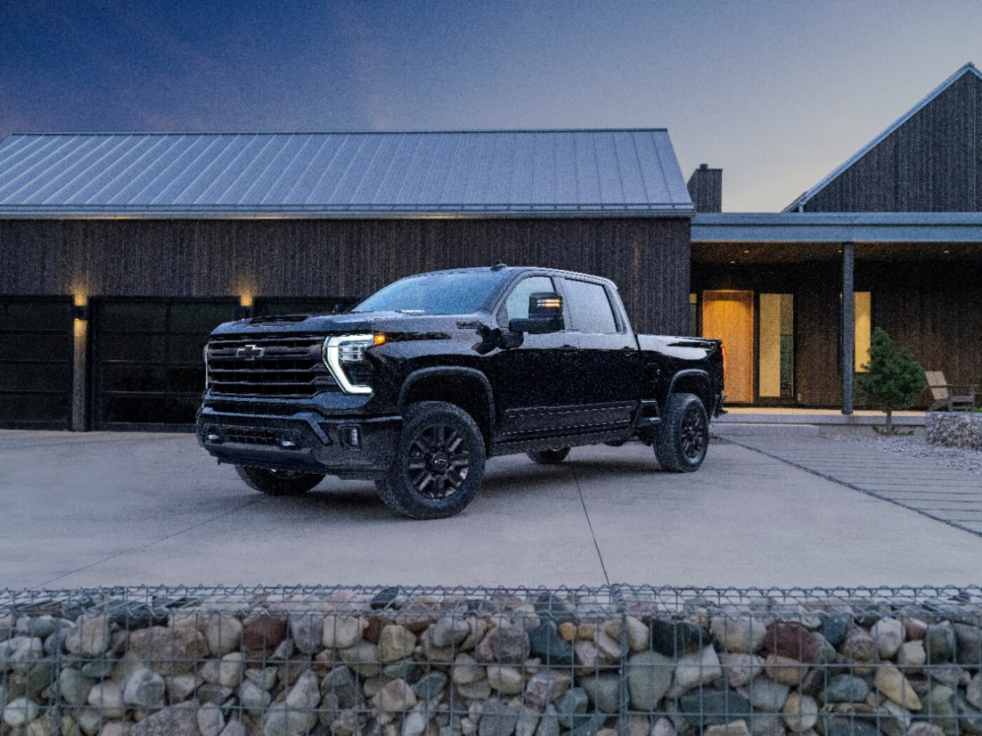  A black Chevy Silverado 2500HD is parked in front of a garage. 