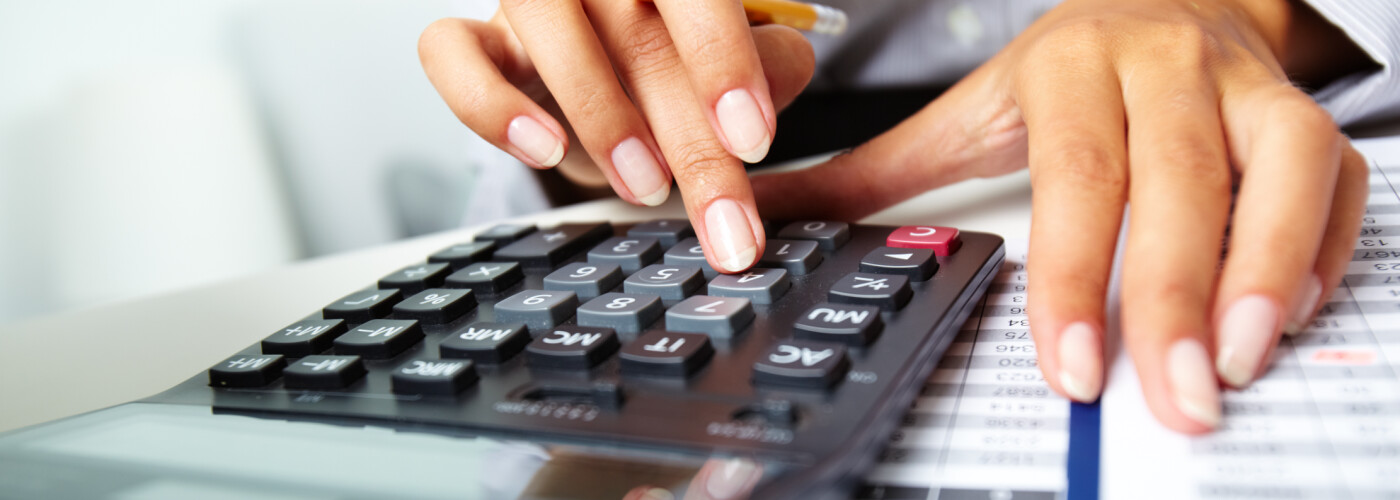Hands Doing Calculations with Calculator