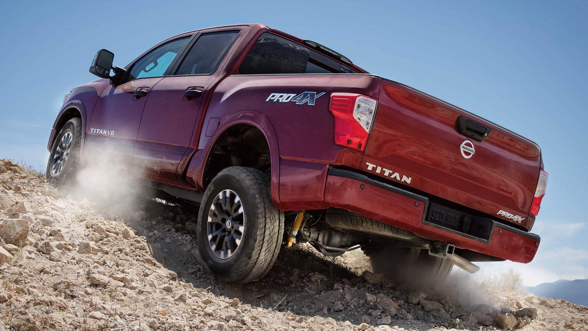 Nissan truck climbing a steep dirt hill