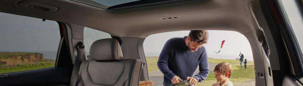 Hyundai Assurance Father and son standing by cargo area of Hyundai SUV