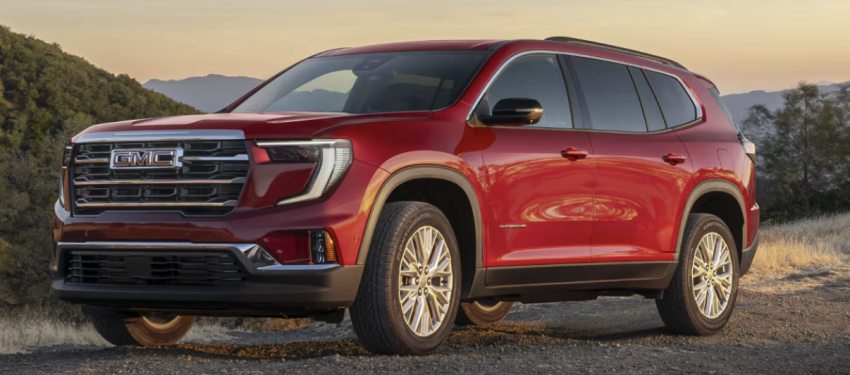 A red suv is parked on a dirt road in the mountains. 