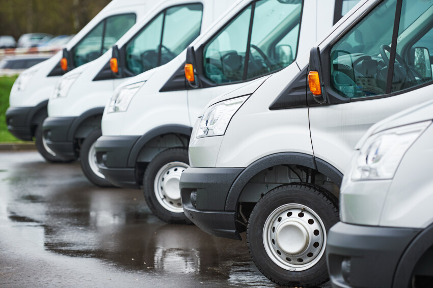 Line up of commercial cargo vans box trucks at dealership 