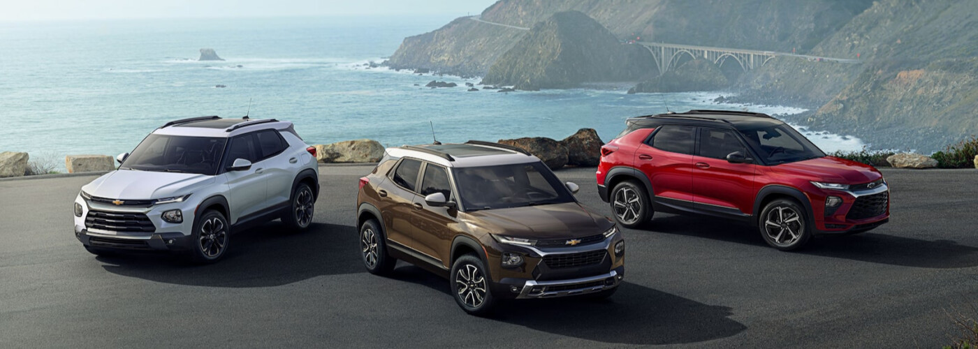 2021 Chevrolet Trailblazer in Summit White, Zeus Bronze, and Scarlet Red White, brown, and red Chevy Trailblazers parked by the ocean