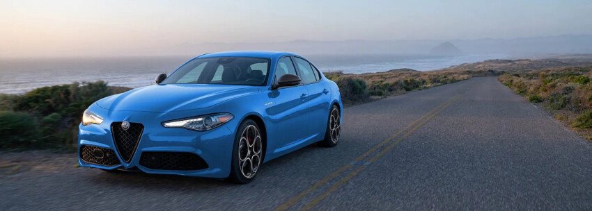 Blue 2022 Alfa Romeo Giulia driving on highway Blue 2022 Alfa Romeo Giulia driving on highway