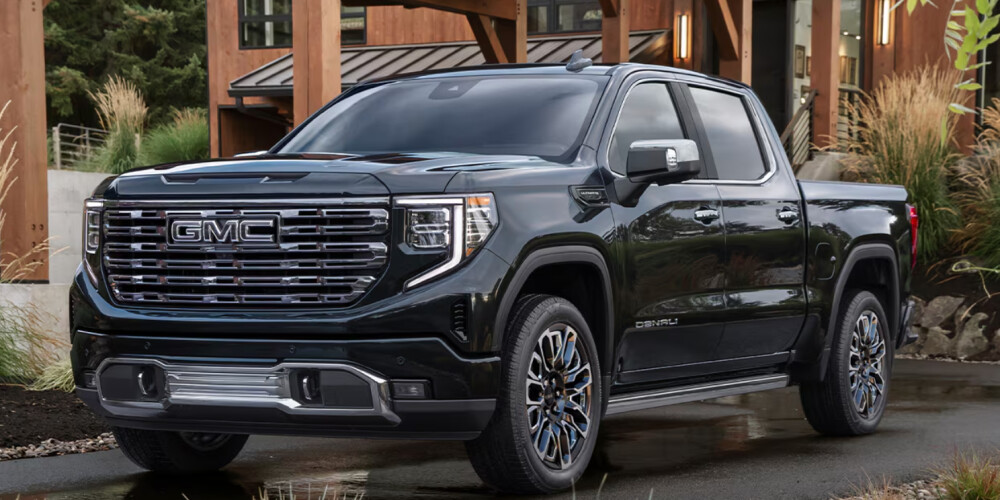 This black Sierra 1500 is parked in front of a lodge.