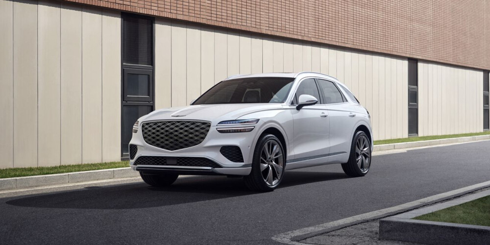 2026 White Genesis GV70 driving on street