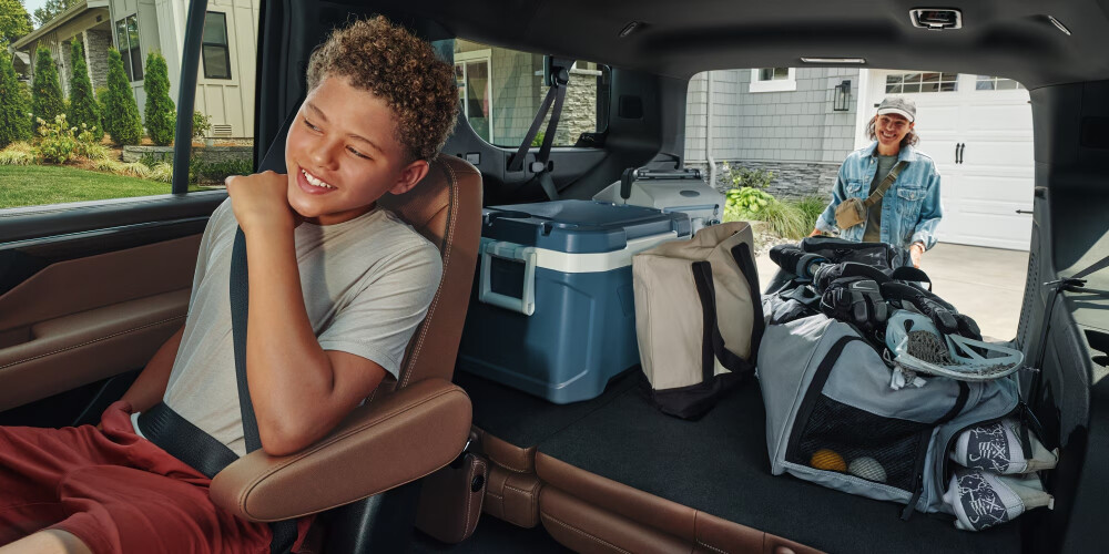 2026 Suburban Interior with child in back seat and adult in rear outside