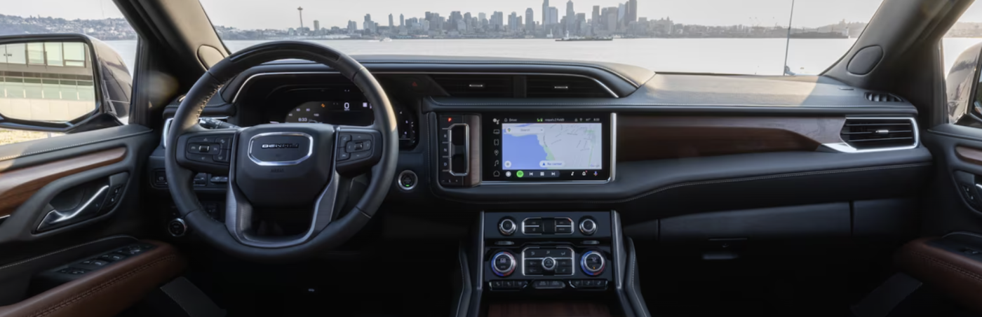 Interior of 2024 GMC Yukon in front of city skyline. 