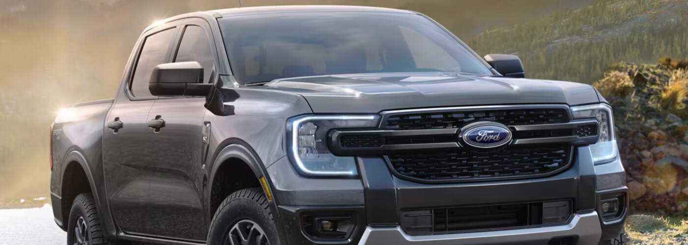 A gray Ford Ranger is parked near a lake.