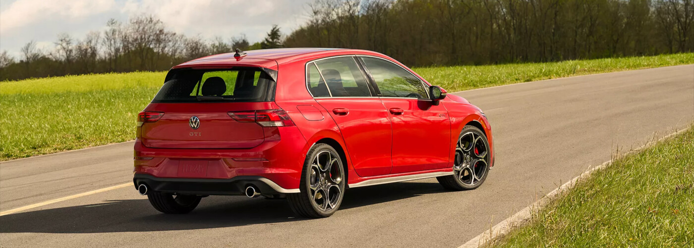 Red 2026 Volkswagen Golf GTI traveling on road towards nature